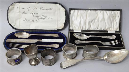 Two cased silver sets, a George IV silver tablespoon, three silver napkins and an egg cup.